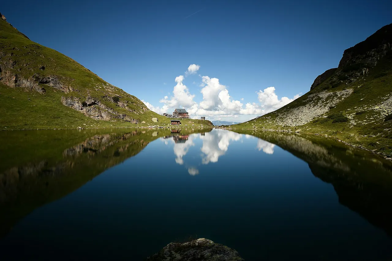 Bergsee zwischen grünen Hängen bei Fieberbrunn, Tirol
